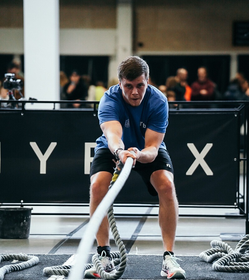 Atlet midt i en HYROX-session, fokus på sled eller løb